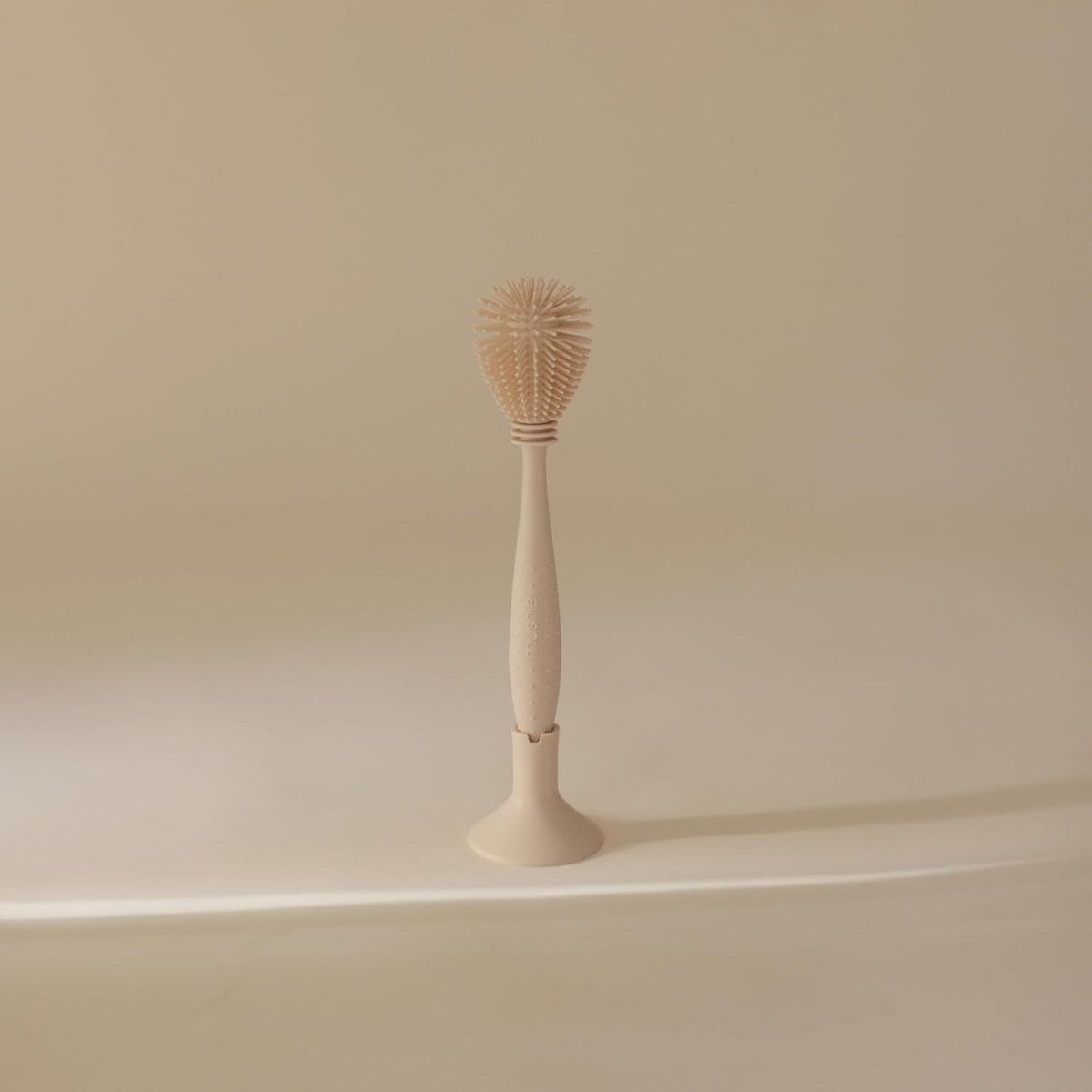 Escova de silicone para mamadeiras Mushie com areia movediça